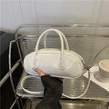 Glossy white oval baguette bag with double handles and long adjustable shoulder strap - White