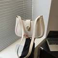 Chic cream beige shoulder bag with gold clasp shown on office desk background - White