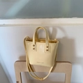 Light yellow glossy PU leather bucket bag with top handles and adjustable shoulder strap - Yellow