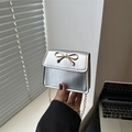 Mini borsa quadrata argento con chiusura a fiocco dorato e catena metallica - Argento