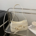 Bolso de hombro crema con lazo dorado elegante y silueta baguette moderna - Blanco