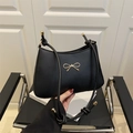 Black underarm shoulder bag with golden bow buckle and knotted leather straps - Black