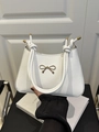 White minimalist square handbag featuring a golden bow buckle and knotted rope handle - White