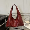 Schicke weinrote Schultertasche aus Lackleder mit minimalistischem Design auf Ständer - Rot