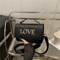 Quilted black crossbody bag with gold Love lettering and a wide nylon shoulder strap - Black