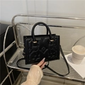 Black embossed floral top-handle crossbody bag with elegant gold hardware decoration - Black