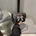 Chic leopard print crossbody bag with a large silver metal bow and chain strap - Tan