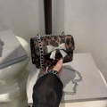 Stylish leopard print crossbody chain bag with a silver metal bow clasp and chain strap - Brown