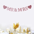 Pink glittery MR & MRS wedding banner with hearts hung over a celebratory table - Rose Gold