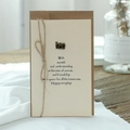 Vintage greeting card with camera metal charm and rustic twine bow on kraft envelope - Camera