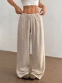 Dettaglio della vita elastica e del tessuto increspato dei pantaloni larghi color beige - S / Albicocca