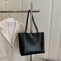 Borsa tote nera classica con trama litchi e scritte dorate appesa su un appendino - Nero