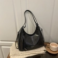 Bolso tote minimalista de cuero sintético negro con correas ajustables sobre un suéter - Negro