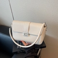 Classic beige rectangular baguette bag with silver buckle and leather strap on books - Off White