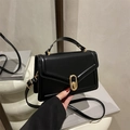 Minimalist black handbag with gold oval twist lock and adjustable shoulder strap - Black