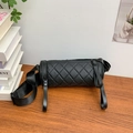 Borsa a cilindro trapuntata nera con tracolla larga in nylon su tavolo di legno - Piccolo / Nero