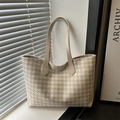 Beige and white houndstooth woven tote bag with leather handles in natural sunlight - Khaki
