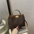 Elegant brown monogram satchel with a gold twist lock and a vintage top handle design - Brown