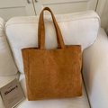 Detalle de la textura de gamuza suave de este amplio bolso tote marrón sobre un sofá - Marrón
