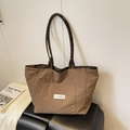 Brown nylon tote bag with leopard print interior and front logo pocket on a leather bench - Side B (Solid Brown Style)