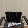 Large black tote bag with animal print texture on a black designer chair with a magazine - Black