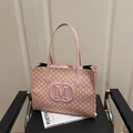Pink tote bag with M-letter monogram print and embossed logo on black leather chair - Pink