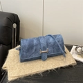 Blaue Denim-Umhängetasche mit silberner H-Schnalle auf einer Strickunterlage - Blau