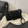 Black leopard print crossbody bag with gold hardware on white silk background - Black