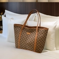 Retro brown monogram tote bag with leather handles in a luxury lifestyle setting - Brown