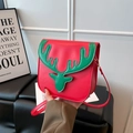 Festive red shoulder bag featuring a green Christmas reindeer design and gold hardware - Red And Green