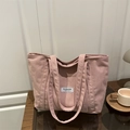 Chic pink corduroy tote bag with Fashion Instinct label on a dark wood table - Pink