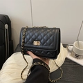 Classic black quilted chain shoulder bag with gold hardware in a lifestyle setting - Black