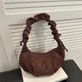 Borsa tote marrone scuro con manico arricciato e consistenza liscia su libri - caffè