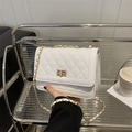 White quilted crossbody bag with gold chain strap and turn-lock closure in chic style - White