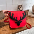 Red shoulder bag with black deer silhouette design and adjustable strap in a cozy setting - Red/Black