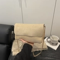 Minimalist beige suede shoulder bag with gold chain strap shown in a cozy cafe setting - Khaki