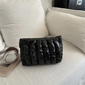 Borsa a mano trapuntata nera con texture a righe su un divano bianco pulito - Nero