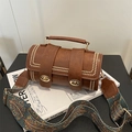 Brown cylinder handbag with golden rivets and ethnic style woven shoulder strap - Brown