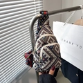 Detailed view of bohemian crossbody bag with woven geometric patterns and multi-zip compartments - Black