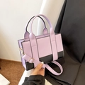 Detail view of purple and black contrast handbag with gold hardware and shoulder strap - Purple (Purple/Black Block)