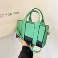 Detalle del bolso bicolor en cuero verde y negro con acabados metálicos dorados - Verde (Verde/Negro Bloque)