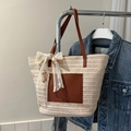 Dettaglio della borsa tote intrecciata beige con tasca in pelle marrone e ciondolo in pizzo - Bianco Sporco