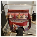 Detail of bohemian woven crossbody bag with colorful tassels and wide patterned strap - Burgundy