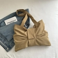Sac à épaule minimaliste en nylon kaki avec nœud et plis sur une parure de lit blanche - Kaki