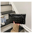 Detail of glossy black patent leather envelope clutch bag with silver metal rivets - Black