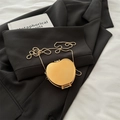 Mini gold heart shaped metal bag with elegant bead chain on black suit background - Gold Apple