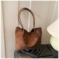Close-up of brown suede tote bag on leather seat highlighting soft matte texture - Brown