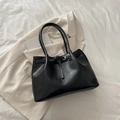 Elegant black leather tote bag with slender strap buckle on white linen and blazer - Black without Pendant