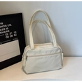 Dettaglio della borsa tote minimalista in tela crema con tasca a zip e spallacci - Bianco avorio