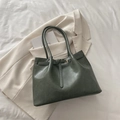 Deep green faux leather tote bag with gold metal buckle on a beige blazer setting - Green Without Pendant